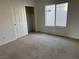 Empty carpeted bedroom featuring a closet with sliding doors and a bright window at 9092 Iron Cactus Ave, Las Vegas, NV 89148