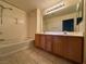 Bright bathroom featuring a double sink vanity, tile floor, and shower-tub combo at 71 E Agate Ave # 207, Las Vegas, NV 89123