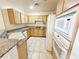 Functional kitchen featuring tile flooring, cabinetry, and white appliances at 71 E Agate Ave # 207, Las Vegas, NV 89123