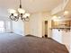 The living room features an elegant chandelier, an open floorplan, and a view to the kitchen at 71 E Agate Ave # 207, Las Vegas, NV 89123