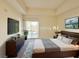 Staged main bedroom features a king bed, TV, and sliding doors to a balcony at 71 E Agate Ave # 207, Las Vegas, NV 89123