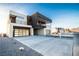 Modern two-story home with a sleek design, two-car garage, and a spacious driveway and desert landscaping at 3690 S Spring Mountain Blvd, Pahrump, NV 89048