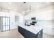 Bright, open kitchen featuring an island with seating, stainless steel appliances, and sleek white cabinetry at 3690 S Spring Mountain Blvd, Pahrump, NV 89048