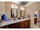 Bright bathroom featuring double sinks, dark wood cabinets, and stylish mirrors at 2035 E Warm Springs Rd # 1019, Las Vegas, NV 89119