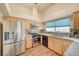 Well-lit kitchen featuring stainless steel appliances, tiled backsplash, and light wood cabinets at 2035 E Warm Springs Rd # 1019, Las Vegas, NV 89119