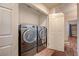 Convenient laundry room setup with modern, front-loading washer and dryer with shelving for organizing supplies at 2035 E Warm Springs Rd # 1019, Las Vegas, NV 89119