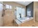 Bathroom with walk-in shower, soaking tub, and a glass block window for natural light at 525 Summer Mesa Dr, Las Vegas, NV 89144
