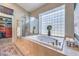 Spa-like bathroom with soaking tub, walk-in shower, and a large block window at 525 Summer Mesa Dr, Las Vegas, NV 89144