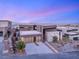 Modern home with stone accents, desert landscaping, three-car garage, and clean architectural lines at 612 Dragon Mountain Ct, Henderson, NV 89012