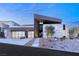 Modern home exterior with clean lines, xeriscaping, and multi-car garage, captured at dusk at 612 Dragon Mountain Ct, Henderson, NV 89012