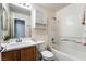 This bathroom has a sink, toilet, bathtub and shower with tiled walls and wood-look floors at 10332 Perfect Parsley St, Las Vegas, NV 89183
