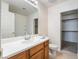 Bathroom with wood vanity, white countertop, and sliding door to closet at 10332 Perfect Parsley St, Las Vegas, NV 89183