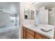 Bathroom with wood cabinets, white countertop, and view into the bedroom at 10332 Perfect Parsley St, Las Vegas, NV 89183