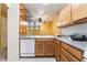 Cozy kitchen featuring wood cabinets, grey granite counters, and a view into the dining area at 10332 Perfect Parsley St, Las Vegas, NV 89183