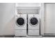 Laundry room featuring a white washer and dryer and storage shelf at 10332 Perfect Parsley St, Las Vegas, NV 89183