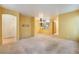 View of a large living room and eat in kitchen with carpet flooring and light yellow walls at 10332 Perfect Parsley St, Las Vegas, NV 89183
