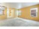 View of a large living room with carpet flooring, neutral walls, and natural light at 10332 Perfect Parsley St, Las Vegas, NV 89183
