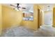 View of a large living room and eat in kitchen with carpet flooring and light yellow walls at 10332 Perfect Parsley St, Las Vegas, NV 89183