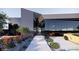 Modern home showcasing an innovative design with a glass-walled garage, landscaped pathway, and desert accents at 491 Cityview Ridge Dr, Henderson, NV 89012