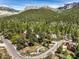 Aerial view of homes nestled in a mountain setting with a stunning backdrop of rocky peaks and abundant trees at 3968 Mont Blanc Way, Las Vegas, NV 89124