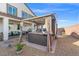 Backyard featuring a hot tub under a pergola with privacy curtains and desert landscaping at 4050 Peaceful Dune St, Las Vegas, NV 89129