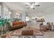 Stylishly furnished living room with a brown leather sofa, patterned rug, and bright natural light at 4050 Peaceful Dune St, Las Vegas, NV 89129