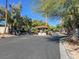 Community entrance featuring a covered kiosk, mature trees, and well-maintained landscaping at 3427 Manzano Cir, Las Vegas, NV 89121