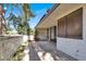 Spacious tiled patio with a white brick wall and lush greenery surrounding the area at 3427 Manzano Cir, Las Vegas, NV 89121