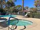 Community pool area featuring a hot tub, swimming pool, lounge chairs, and lush landscaping at 3427 Manzano Cir, Las Vegas, NV 89121