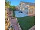 Spacious backyard featuring artificial turf, stone details, and a concrete patio at 11261 Playa Caribe Ave, Las Vegas, NV 89138