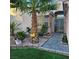 Inviting front entrance with a tiled walkway, lush landscaping, and a decorative palm tree at 11261 Playa Caribe Ave, Las Vegas, NV 89138