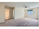 A carpeted bedroom includes a ceiling fan, a window with green shades, and entryways to other rooms at 2731 Heathrow St, Las Vegas, NV 89135