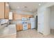 Bright kitchen featuring white appliances, wood cabinets, and tile flooring at 2731 Heathrow St, Las Vegas, NV 89135