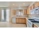 Spacious kitchen with stainless steel sink, white appliances, wood cabinetry and tile flooring at 2731 Heathrow St, Las Vegas, NV 89135