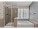 Bathroom with shower, bathtub, and window overlooking the pool at 3767 Darren Thornton Way, Las Vegas, NV 89120