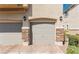 Attached two-car garage with gray doors and stone accents at 10111 Aspen Rose St # 101, Las Vegas, NV 89183