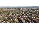 An aerial view shows a community with neatly arranged houses, tree-lined streets, and a distant view of the city skyline and mountains at 11605 Cabo Del Sol Ct, Las Vegas, NV 89138