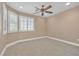 Neutral bedroom features plush carpeting, a ceiling fan, and natural light from the windows at 11605 Cabo Del Sol Ct, Las Vegas, NV 89138