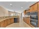 Well-lit kitchen featuring granite countertops, wood cabinets, and modern appliances at 11605 Cabo Del Sol Ct, Las Vegas, NV 89138