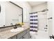 Bathroom with granite countertop and striped shower curtain at 49 Vista Outlook St, Henderson, NV 89011