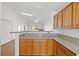 Spacious kitchen featuring wooden cabinets and breakfast bar counter at 7814 Ravenhollow Ln, Las Vegas, NV 89145