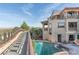 Mediterranean-style home exterior featuring a bridge to backyard, a pool, a spa, and an upper-level balcony at 8 Rue Mediterra Dr, Henderson, NV 89011
