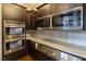 Modern kitchen appliances featuring stainless steel ovens, microwave, drawers, and dark wood cabinetry at 8 Rue Mediterra Dr, Henderson, NV 89011