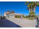 Long driveway leading to a two-car garage and a meticulously landscaped front yard with vibrant flowers and manicured bushes at 485 Sari Dr, Las Vegas, NV 89110