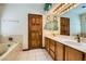 Double vanity bathroom with wood cabinets and a large mirror at 3189 Lipton Ct, Las Vegas, NV 89121