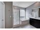 Modern bathroom with a large shower, a soaking tub, and dark wood cabinets at 3164 Rowan Brook Ave, Henderson, NV 89052