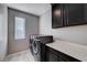 Laundry room with washer, dryer, and dark brown cabinets at 3164 Rowan Brook Ave, Henderson, NV 89052