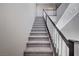 Modern carpeted staircase with dark wood railing at 3164 Rowan Brook Ave, Henderson, NV 89052