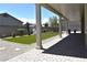 Backyard view from the covered patio with artificial turf, desert landscaping, and rock features at 7047 Noble Flair Ct, Las Vegas, NV 89131