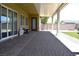Covered patio with stone pavers and backyard access, overlooking artificial turf and desert landscaping at 7047 Noble Flair Ct, Las Vegas, NV 89131